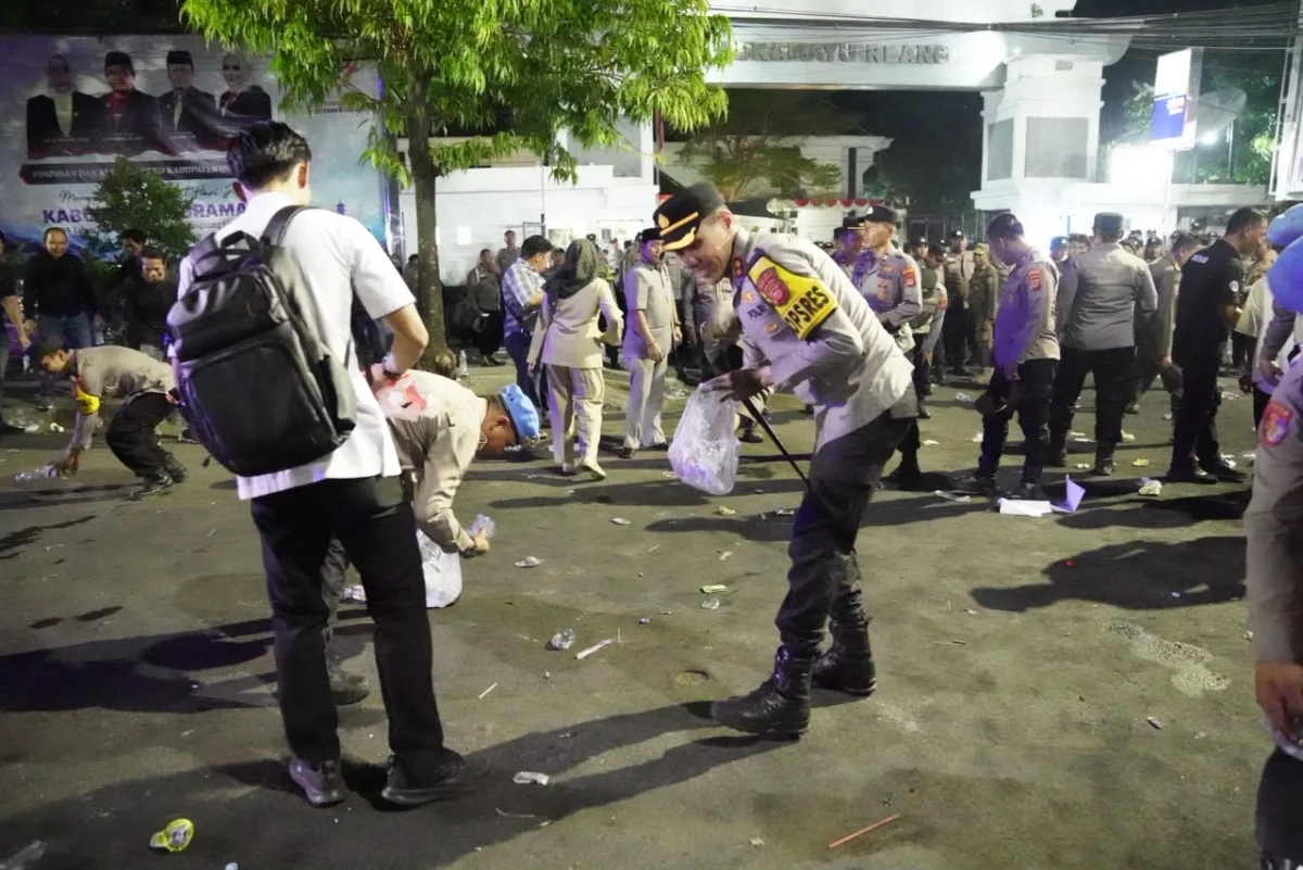 Kapolres Indramayu AKBP Prianggo P. M. bersama personel kepolisian membersihkan sampah di depan Gedung DPRD setelah aksi demonstrasi mahasiswa Cipayung Plus, Kamis (29/10/2026).